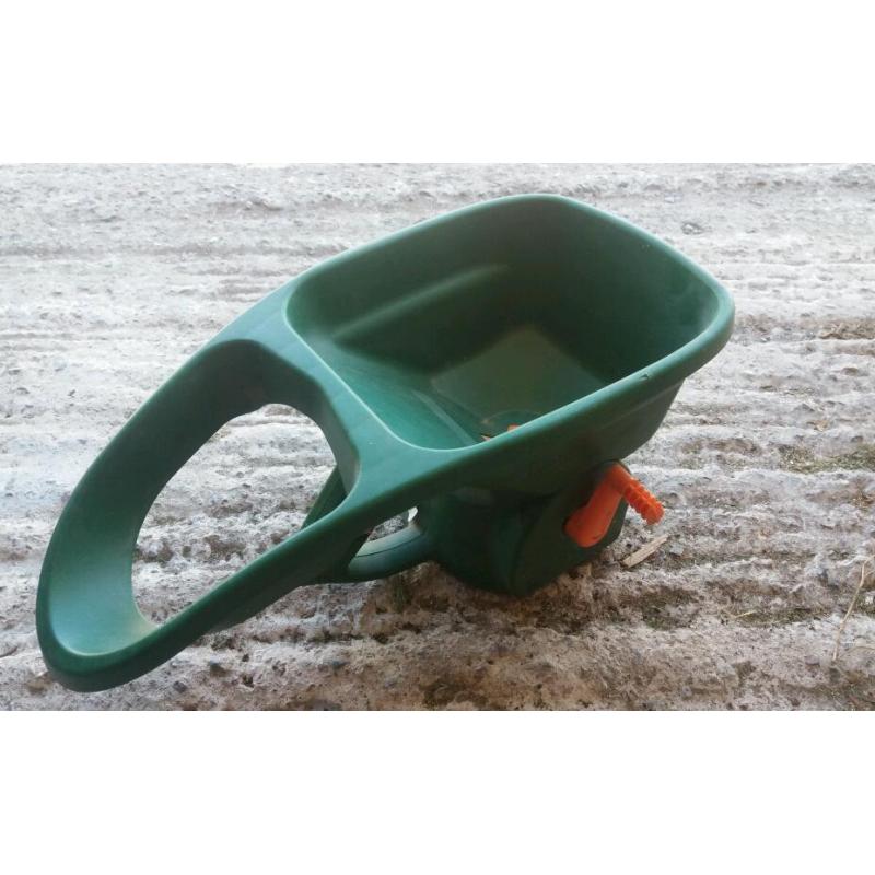 Hand held fertilizer spreader