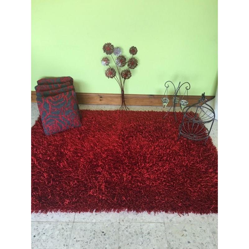 Thick red rug, metal wall art . Cushions